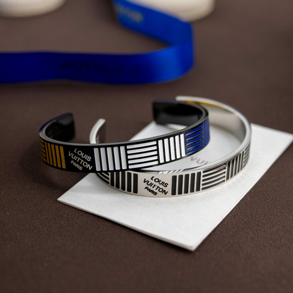 Bracelet jonc ouvert rigide à rayures et signature